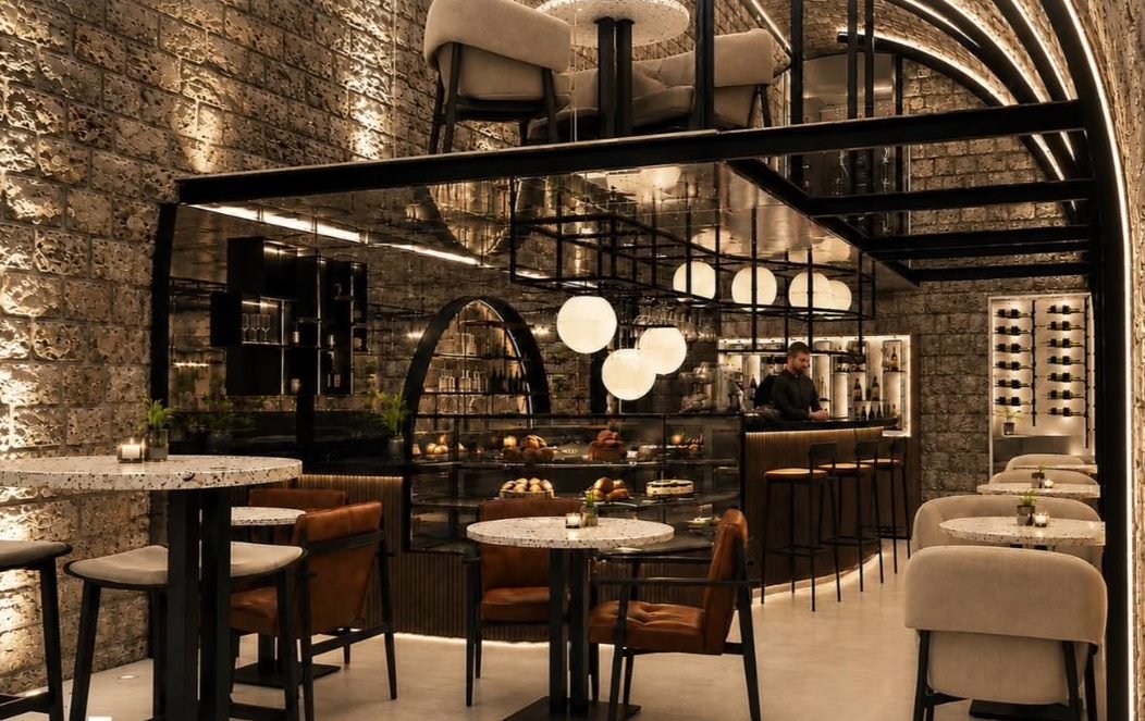 The main hall — stone vaults, mirrored bar, terrazzo tables and globe lamps