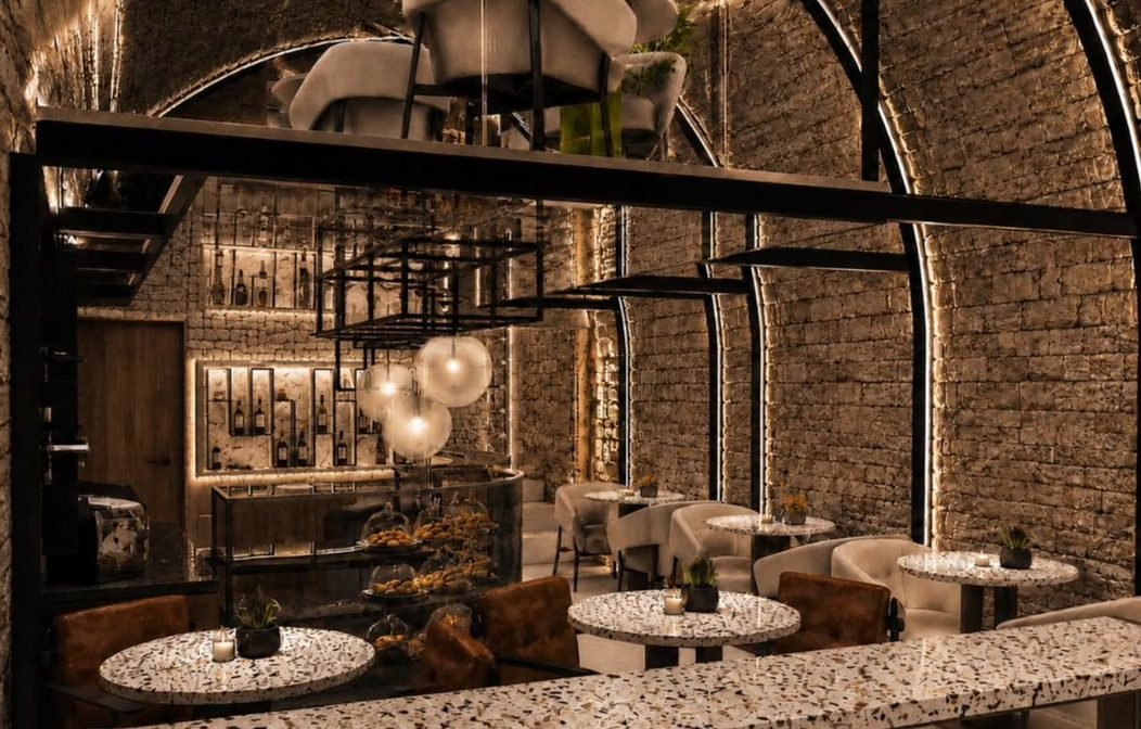 Terrazzo tables and leather seats beneath the arches