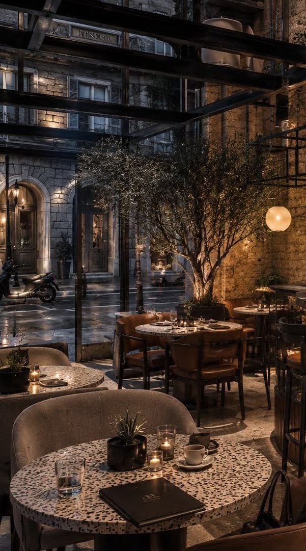 The café side of the hall — terrazzo tables and leather chairs by the old souk window